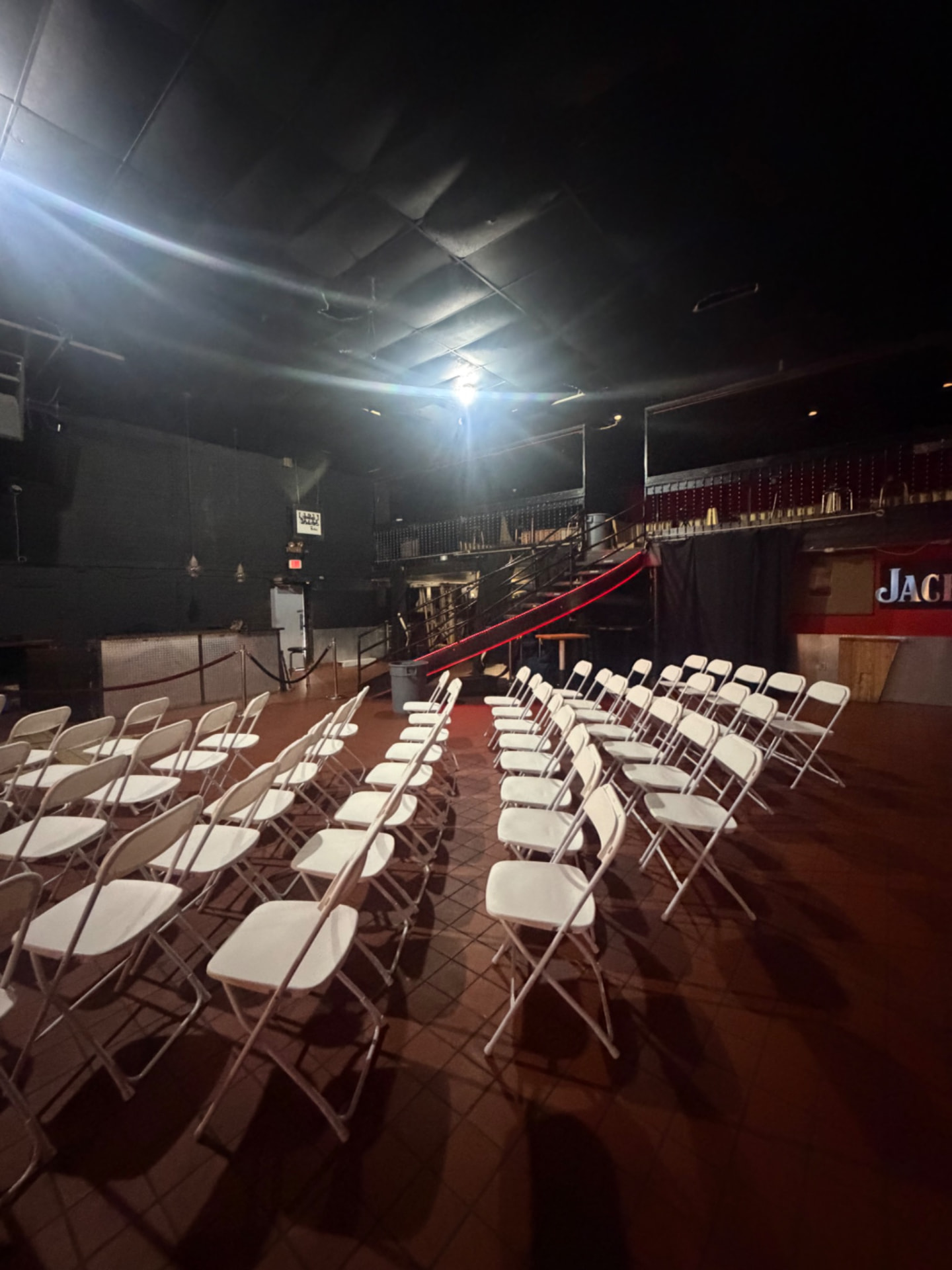 White folding chair seating arranged inside an indoor event venue